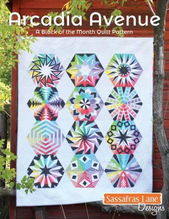 Photo: White quilt with 12 hexagons, each containing a different pattern showing a rainbow spectrum.  Arcadia Avenue Quilt Pattern - Sassafras Lane Designs