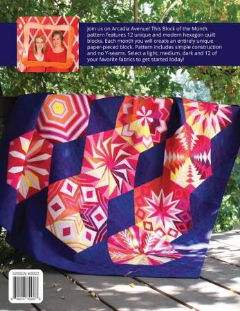 Photo of dark blue/purple quilt with 12 hexagons, each showing a different pattern in warm shades (red, yellow, pink)